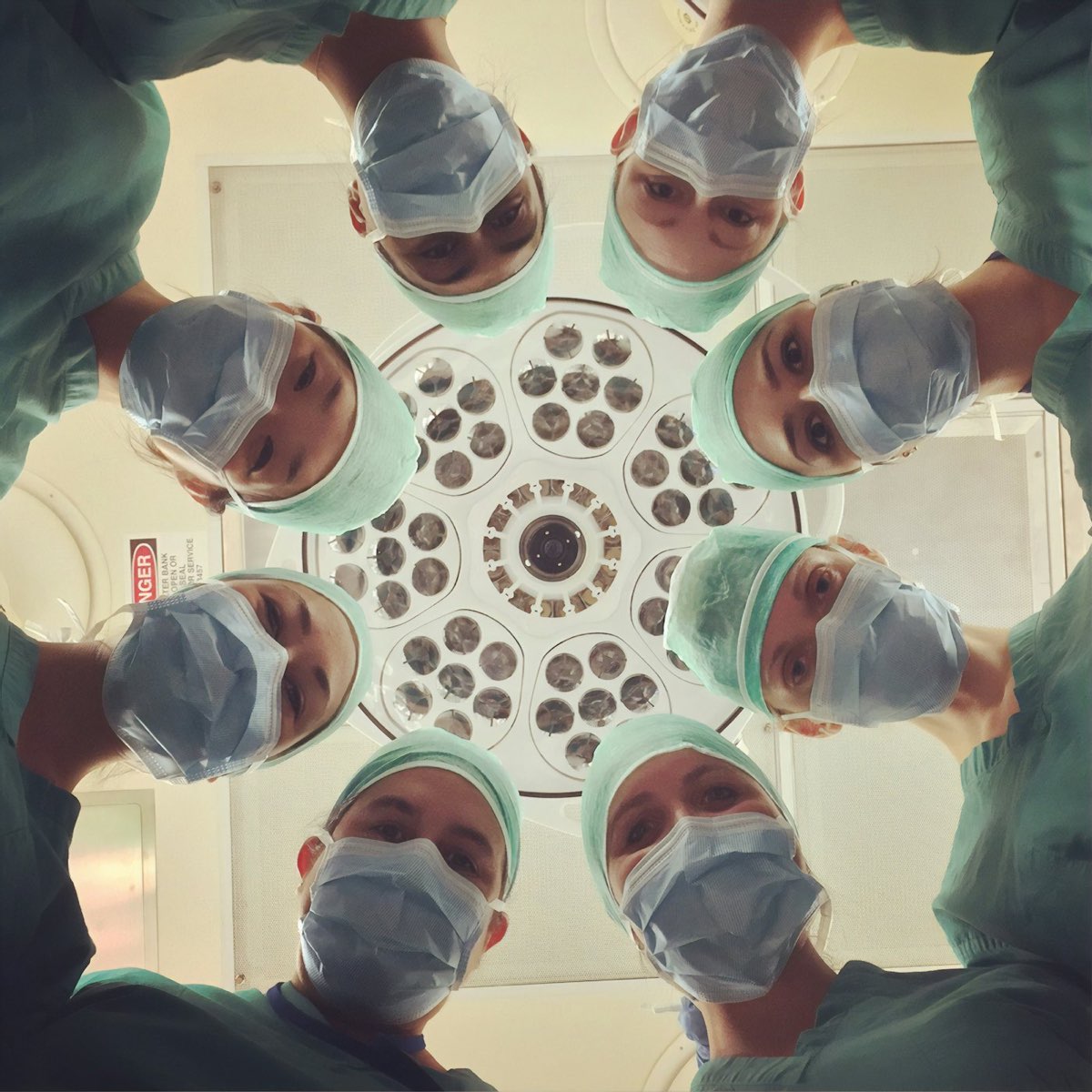 Equipo médico en un quirófano, visto desde la lámpara quirúrgica